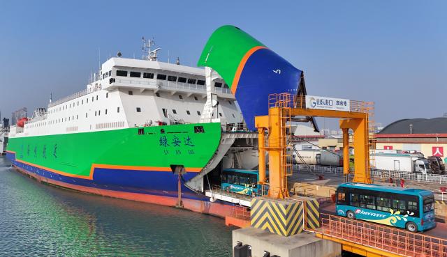 (260312) -- BEIJING, March 12, 2026 (Xinhua) -- A drone photo taken on Nov. 30, 2025 shows electric buses boarding a new energy vehicle carrier at Yantai Port in east China's Shandong Province. (Photo by Tang Ke/Xinhua)