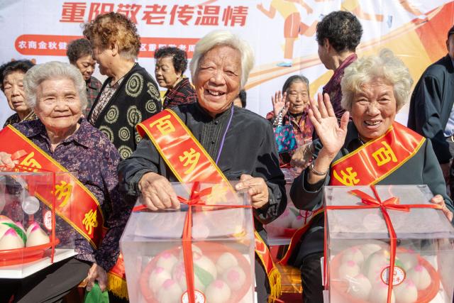(260312) -- BEIJING, March 12, 2026 (Xinhua) -- Senior citizens hold gift boxes containing peach-shaped buns, which symbolize longevity, during an event celebrating the Chongyang Festival, also known as China's Seniors' Day, in Lucheng District of Wenzhou City, east China's Zhejiang Province, Oct. 27, 2025. (Photo by Liu Jili/Xinhua)