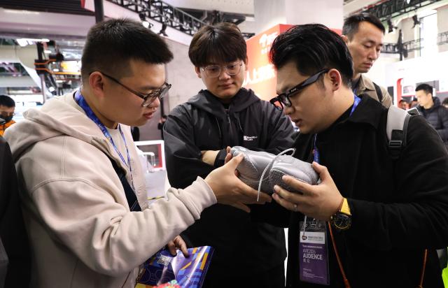 (260312) -- SHANGHAI, March 12, 2026 (Xinhua) -- Visitors look at a 3D-printed shoe during the 2026 Appliance & Electronics World Expo (AWE2026) in east China's Shanghai, March 12, 2026. The AWE2026 kicked off in Shanghai on Thursday. More than 1,200 enterprises from all over the world gathered at the expo to showcase their latest innovations. (Xinhua/Fang Zhe)