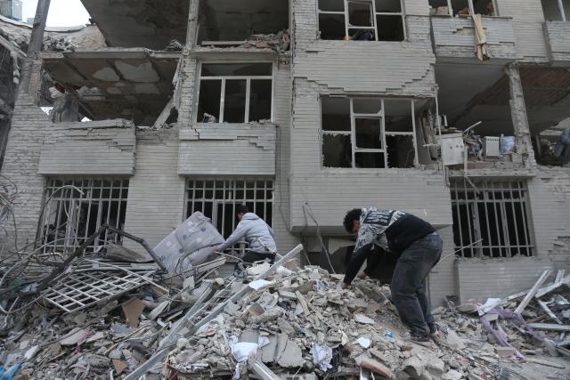 (260312) -- TEHRAN, March 12, 2026 (Xinhua) -- People search for daily necessities from damaged buildings in Tehran, Iran, March 12, 2026. (Xinhua/Shadati)