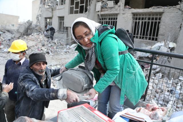 (260312) -- TEHRAN, March 12, 2026 (Xinhua) -- People search for daily necessities from damaged buildings in Tehran, Iran, March 12, 2026. (Xinhua/Shadati)