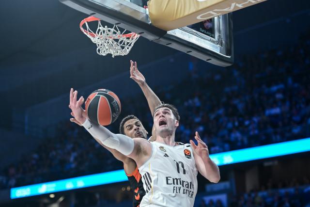 (260313) -- MADRID, March 13, 2026 (Xinhua) -- Real Madrid's Mario Hezonja (R) goes for a layup against Valencia's Neal Sako during the Euroleague basketball match between Real Madrid and Valencia in Madrid, Spain, on March 12, 2026. (Photo by Gustavo Valiente/Xinhua)