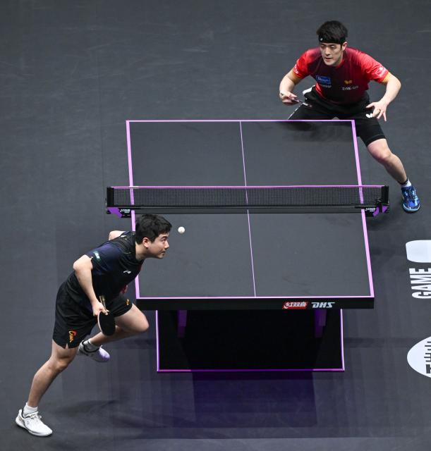 (260313) -- CHONGQING, March 13, 2026 (Xinhua) -- Liang Jingkun (L) serves during the men's singles round of 16 match between Liang Jingkun of China and Qiu Dang of Germany at the WTT Champions Chongqing 2026 in southwest China's Chongqing, March 13, 2026. (Xinhua/Chen Cheng)
