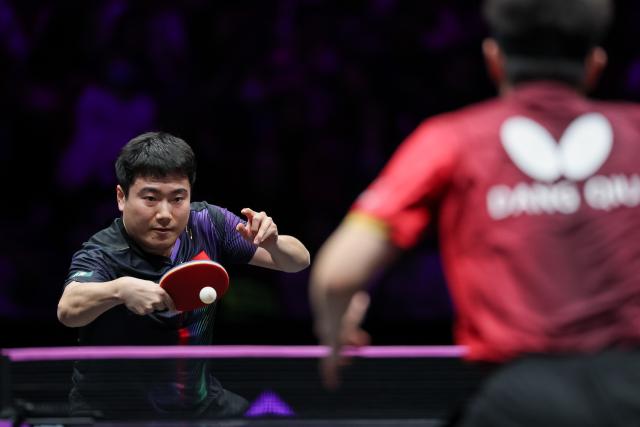 (260313) -- CHONGQING, March 13, 2026 (Xinhua) -- Liang Jingkun (L) hits a return during the men's singles round of 16 match between Liang Jingkun of China and Qiu Dang of Germany at the WTT Champions Chongqing 2026 in southwest China's Chongqing, March 13, 2026. (Xinhua/Huang Wei)
