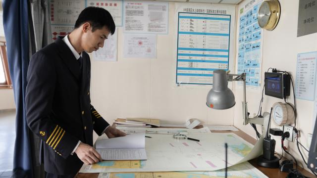 (260313) -- HAIKOU, March 13, 2026 (Xinhua) -- Ro-ro passenger ship captain Huang Wanli prepares for sailing at the cab of the "Shuangtai 36" in Haikou, south China's Hainan Province, Feb. 3, 2026. TO GO WITH: "Across China: Captain of a 'ro-ro' passenger ship across south China's Qiongzhou Strait" (Xinhua/Xu Yushen)