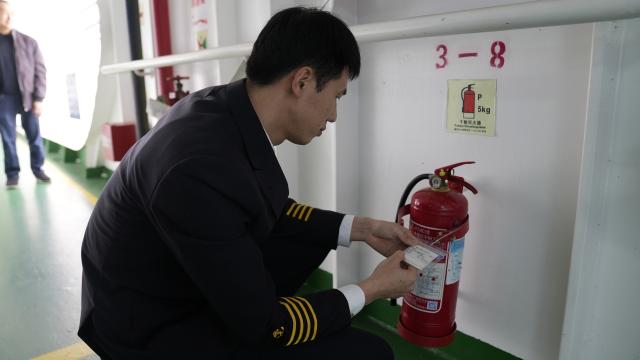 (260313) -- HAIKOU, March 13, 2026 (Xinhua) -- Ro-ro passenger ship captain Huang Wanli inspects fire-fighting equipment aboard in Haikou, south China's Hainan Province, Feb. 3, 2026. TO GO WITH: "Across China: Captain of a 'ro-ro' passenger ship across south China's Qiongzhou Strait" (Xinhua/Xu Yushen)