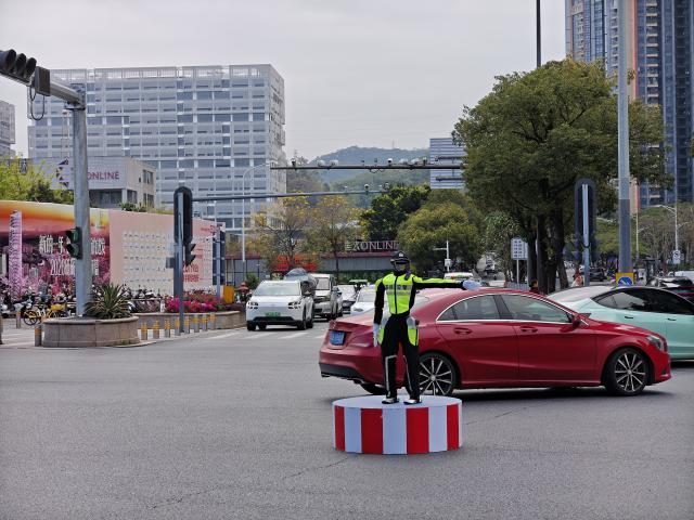 (260313) -- SHENZHEN, March 13, 2026 (Xinhua) -- This photo taken with a mobile phone shows a robotic traffic commander directing traffic at a road intersection in Longgang District, Shenzhen, south China's Guangdong Province, March 6, 2026. TO GO WITH "Across China: Robotic traffic police commander debuts in south China's Shenzhen" (Shenzhen Traffic Police/Handout via Xinhua)
