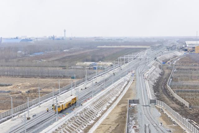 (260313) -- HARBIN, March 13, 2026 (Xinhua) -- A drone photo taken on March 13, 2026 shows the construction site of Suihua South Station of the Harbin-Yichun high-speed railway in Suihua, northeast China's Heilongjiang Province. Workers from China Railway Wuhan Electrification Bureau Group are pressing ahead with the construction of the communication, signaling and power supply systems for the 318-kilometer Harbin-Yichun high-speed railway. At present, 90% of the project has been completed. (Xinhua/Zhang Tao)