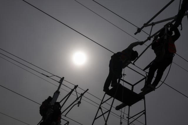 (260313) -- HARBIN, March 13, 2026 (Xinhua) -- Workers install catenary systems at the construction site of Suihua South Station of the Harbin-Yichun high-speed railway in Suihua, northeast China's Heilongjiang Province, March 13, 2026. Workers from China Railway Wuhan Electrification Bureau Group are pressing ahead with the construction of the communication, signaling and power supply systems for the 318-kilometer Harbin-Yichun high-speed railway. At present, 90% of the project has been completed. (Xinhua/Zhang Tao)