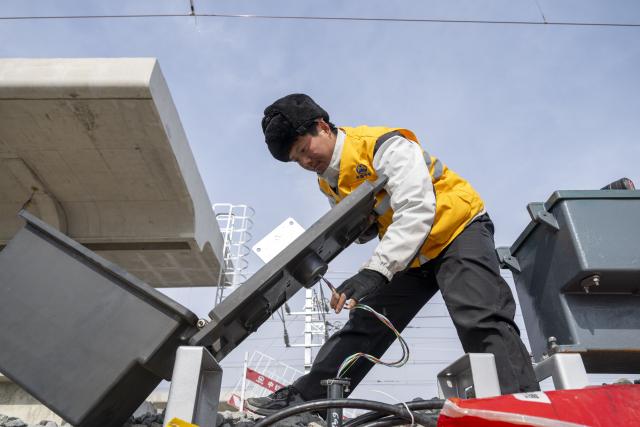 (260313) -- HARBIN, March 13, 2026 (Xinhua) -- A worker installs signal equipment at the construction site of Suihua South Station of the Harbin-Yichun high-speed railway in Suihua, northeast China's Heilongjiang Province, March 13, 2026. Workers from China Railway Wuhan Electrification Bureau Group are pressing ahead with the construction of the communication, signaling and power supply systems for the 318-kilometer Harbin-Yichun high-speed railway. At present, 90% of the project has been completed. (Xinhua/Zhang Tao)