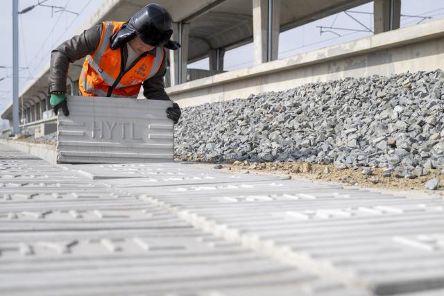 (260313) -- HARBIN, March 13, 2026 (Xinhua) -- A worker installs signal equipment at the construction site of Suihua South Station of the Harbin-Yichun high-speed railway in Suihua, northeast China's Heilongjiang Province, March 13, 2026. Workers from China Railway Wuhan Electrification Bureau Group are pressing ahead with the construction of the communication, signaling and power supply systems for the 318-kilometer Harbin-Yichun high-speed railway. At present, 90% of the project has been completed. (Xinhua/Zhang Tao)