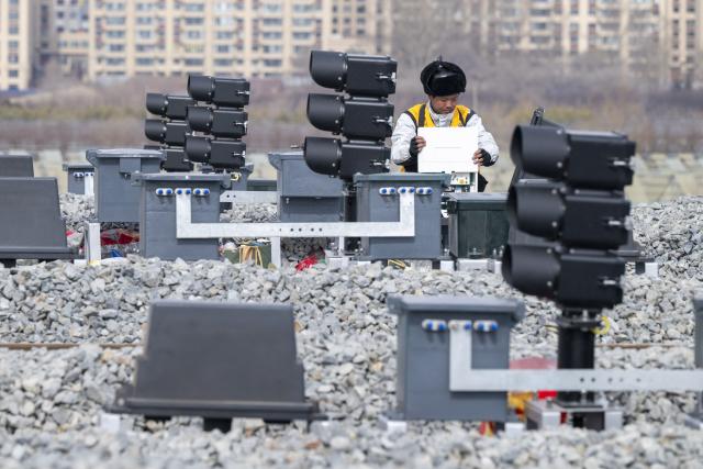 (260313) -- HARBIN, March 13, 2026 (Xinhua) -- A worker installs signal equipment at the construction site of Suihua South Station of the Harbin-Yichun high-speed railway in Suihua, northeast China's Heilongjiang Province, March 13, 2026. Workers from China Railway Wuhan Electrification Bureau Group are pressing ahead with the construction of the communication, signaling and power supply systems for the 318-kilometer Harbin-Yichun high-speed railway. At present, 90% of the project has been completed. (Xinhua/Zhang Tao)