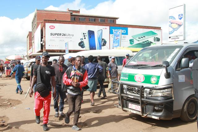 (260313) -- HARARE, March 13, 2026 (Xinhua) -- People walk past parked public transport vehicles at a station in Harare, Zimbabwe, on March 11, 2026. Amid rising crude oil prices due to the conflict in the Middle East, Zimbabweans are already feeling the squeeze at the fuel pump.
  Commuters in Harare, Zimbabwe's capital, are bearing the brunt of higher transportation costs, as fuel price hikes have forced some public transport operators to raise fares.
  TO GO WITH "Roundup: Rising fuel prices weigh on Zimbabwean commuters amid Middle East crisis" (Photo by Tafara Mugwara/Xinhua)