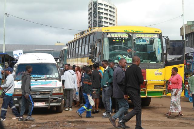 (260313) -- HARARE, March 13, 2026 (Xinhua) -- People are seen in front of parked public transport vehicles at a station in Harare, Zimbabwe, on March 11, 2026. Amid rising crude oil prices due to the conflict in the Middle East, Zimbabweans are already feeling the squeeze at the fuel pump.
  Commuters in Harare, Zimbabwe's capital, are bearing the brunt of higher transportation costs, as fuel price hikes have forced some public transport operators to raise fares.
  TO GO WITH "Roundup: Rising fuel prices weigh on Zimbabwean commuters amid Middle East crisis" (Photo by Tafara Mugwara/Xinhua)