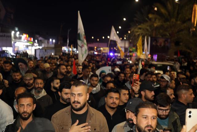 (260313) -- BAGHDAD, March 13, 2026 (Xinhua) -- People attend a funeral for deceased Iraqi paramilitary Popular Mobilization Forces (PMF) members in Baghdad, Iraq, on March 12, 2026. Airstrikes on the 19th Brigade headquarters in Akashat near the Syrian border in Iraq's Anbar province killed at least 32 personnel belonging to the PMF and wounded 65 others on Thursday Morning, a provincial security source told Xinhua on condition of anonymity. (Xinhua/Khalil Dawood)