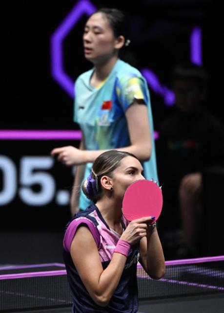 (260313) -- CHONGQING, March 13, 2026 (Xinhua) -- Bernadette Szocs (down) of Romania reacts during the women's singles round of 16 match against Chen Yi of China at the WTT Champions Chongqing 2026 in southwest China's Chongqing, March 13, 2026. (Xinhua/Chen Cheng)