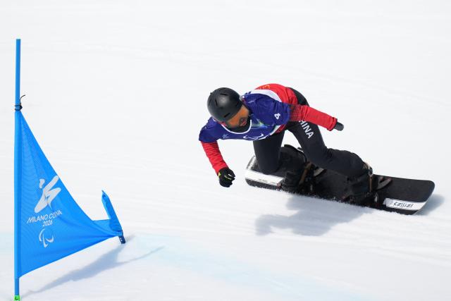 (260313) -- CORTINA D'AMPEZZO, March 13, 2026 (Xinhua) -- Wang Pengyao of China competes during the Para Snowboard Men's Banked Slalom SB-UL event at the Milan-Cortina 2026 Paralympic Winter Games in Cortina D'ampezzo, Italy, March 13, 2026. (Xinhua/Lian Yi)
