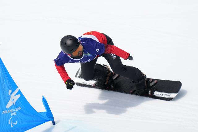 (260313) -- CORTINA D'AMPEZZO, March 13, 2026 (Xinhua) -- Wang Pengyao of China competes during the Para Snowboard Men's Banked Slalom SB-UL event at the Milan-Cortina 2026 Paralympic Winter Games in Cortina D'ampezzo, Italy, March 13, 2026. (Xinhua/Lian Yi)