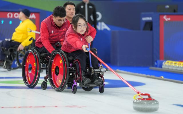 (260313) -- CORTINA D'AMPEZZO, March 13, 2026 (Xinhua) -- Li Nana (R) of China competes during the wheelchair curling mixed team semifinal match between China and Sweden at the Milan-Cortina 2026 Paralympic Winter Games in Cortina D'ampezzo, Italy, March 13, 2026. (Xinhua/Wang Kaiyan)