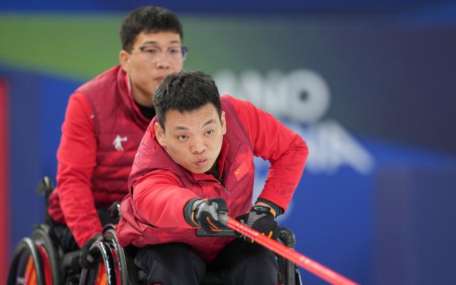 (260313) -- CORTINA D'AMPEZZO, March 13, 2026 (Xinhua) -- Zhang Mingliang (R) of China competes during the wheelchair curling mixed team semifinal match between China and Sweden at the Milan-Cortina 2026 Paralympic Winter Games in Cortina D'ampezzo, Italy, March 13, 2026. (Xinhua/Wang Kaiyan)