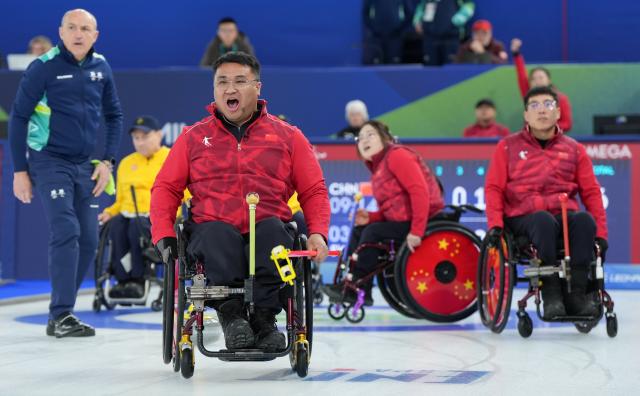 (260313) -- CORTINA D'AMPEZZO, March 13, 2026 (Xinhua) -- Wang Haitao (front) of China competes during the wheelchair curling mixed team semifinal match between China and Sweden at the Milan-Cortina 2026 Paralympic Winter Games in Cortina D'ampezzo, Italy, March 13, 2026. (Xinhua/Wang Kaiyan)
