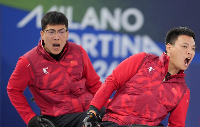 (260313) -- CORTINA D'AMPEZZO, March 13, 2026 (Xinhua) -- Zhang Mingliang (R) and Chen Jianxin of China react during the wheelchair curling mixed team semifinal match between China and Sweden at the Milan-Cortina 2026 Paralympic Winter Games in Cortina D'ampezzo, Italy, March 13, 2026. (Xinhua/Wang Kaiyan)