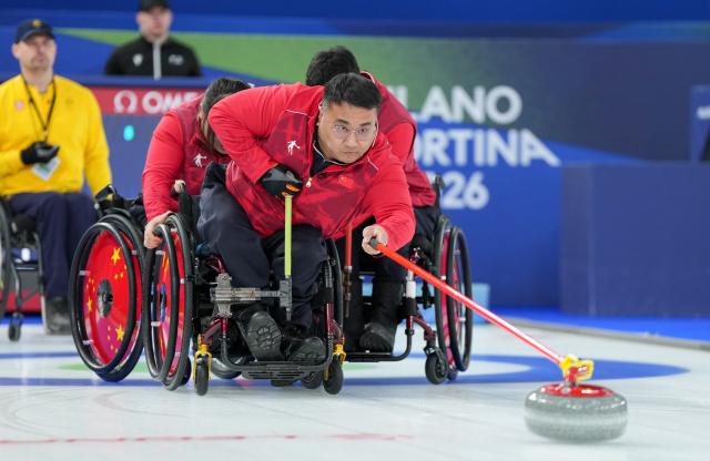 (260313) -- CORTINA D'AMPEZZO, March 13, 2026 (Xinhua) -- Wang Haitao (front) of China competes during the wheelchair curling mixed team semifinal match between China and Sweden at the Milan-Cortina 2026 Paralympic Winter Games in Cortina D'ampezzo, Italy, March 13, 2026. (Xinhua/Wang Kaiyan)