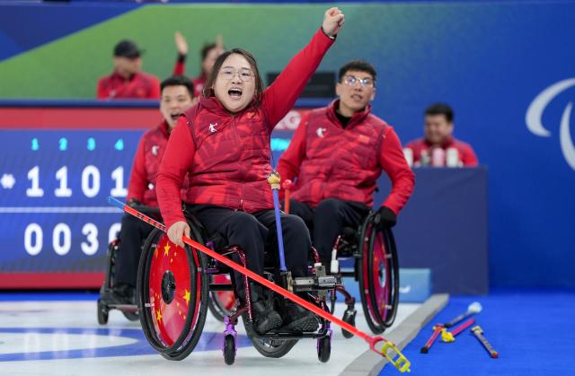 (260313) -- CORTINA D'AMPEZZO, March 13, 2026 (Xinhua) -- Li Nana (front) of China celebrates during the wheelchair curling mixed team semifinal match between China and Sweden at the Milan-Cortina 2026 Paralympic Winter Games in Cortina D'ampezzo, Italy, March 13, 2026. (Xinhua/Wang Kaiyan)