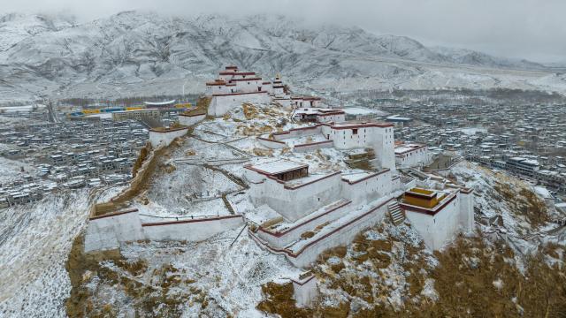 (260313) -- XIGAZE, March 13, 2026 (Xinhua) -- This aerial photo taken on March 13, 2026 shows the snow scenery of ancient white castles on Mt. Dzongri in Gyantse, Xigaze City, southwest China's Xizang Autonomous Region. (Xinhua/Jigme Dorje)