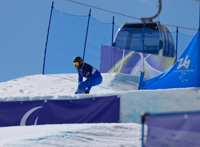 (260313) -- CORTINA D'AMPEZZO, March 13, 2026 (Xinhua) -- Emanuel Perathoner of Italy competes during the Para Snowboard Men's Banked Slalom LL2 event at the Milan-Cortina 2026 Paralympic Winter Games in Cortina D'ampezzo, Italy, March 13, 2026. (Xinhua/Mu Yu)