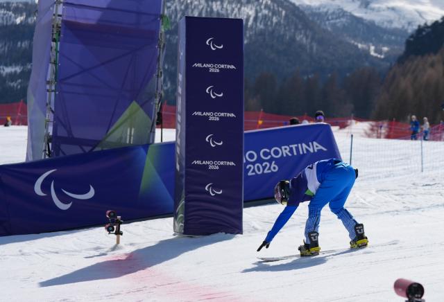 (260313) -- CORTINA D'AMPEZZO, March 13, 2026 (Xinhua) -- Emanuel Perathoner of Italy competes during the Para Snowboard Men's Banked Slalom LL2 event at the Milan-Cortina 2026 Paralympic Winter Games in Cortina D'ampezzo, Italy, March 13, 2026. (Xinhua/Mu Yu)