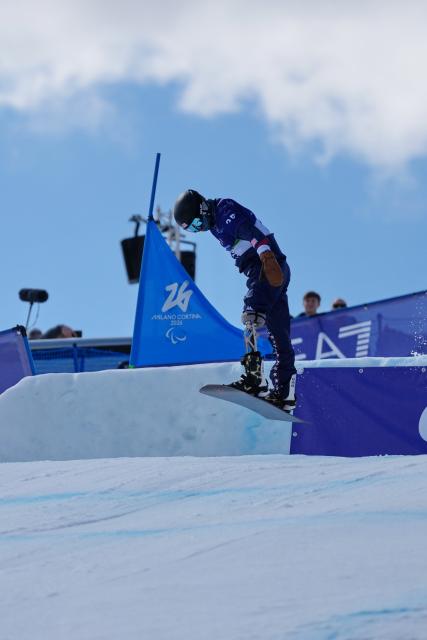 (260313) -- CORTINA D'AMPEZZO, March 13, 2026 (Xinhua) -- Noah Elliott of the United States competes during the Para Snowboard Men's Banked Slalom LL1 event at the Milan-Cortina 2026 Paralympic Winter Games in Cortina D'ampezzo, Italy, March 13, 2026. (Xinhua/Mu Yu)