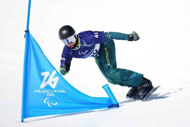(260313) -- CORTINA D'AMPEZZO, March 13, 2026 (Xinhua) -- Ben Tudhope of Australia competes during the Para Snowboard Men's Banked Slalom SB-LL2 event at the Milan-Cortina 2026 Paralympic Winter Games in Cortina D'ampezzo, Italy, March 13, 2026. (Xinhua/Lian Yi)