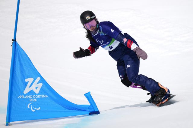 (260313) -- CORTINA D'AMPEZZO, March 13, 2026 (Xinhua) -- Brenna Huckaby of the United States competes during the Para Snowboard Women's Banked Slalom SB-LL2 event at the Milan-Cortina 2026 Paralympic Winter Games in Cortina D'ampezzo, Italy, March 13, 2026. (Xinhua/Lian Yi)
