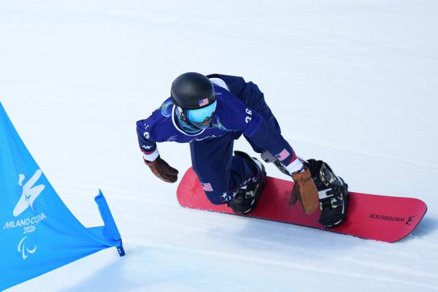 (260313) -- CORTINA D'AMPEZZO, March 13, 2026 (Xinhua) -- Noah Elliott of the United States competes during the Para Snowboard Men's Banked Slalom LL1 event at the Milan-Cortina 2026 Paralympic Winter Games in Cortina D'ampezzo, Italy, March 13, 2026. (Xinhua/Lian Yi)