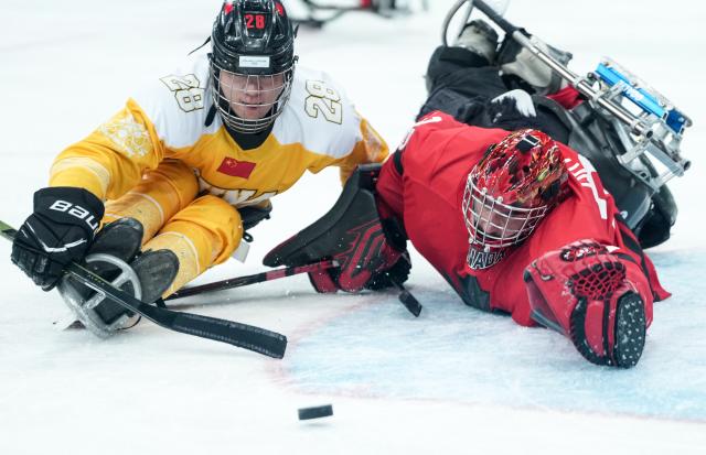 (260314) -- MILAN, March 14, 2026 (Xinhua) -- Tian Jintao (L)of China vies with Corbin Watson of Canada during the Para Ice Hockey semifinal match between the Canada and China at the Milan-Cortina 2026 Paralympic Winter Games in Milan , Italy, March 13, 2025. (Xinhua/Li Jing)
