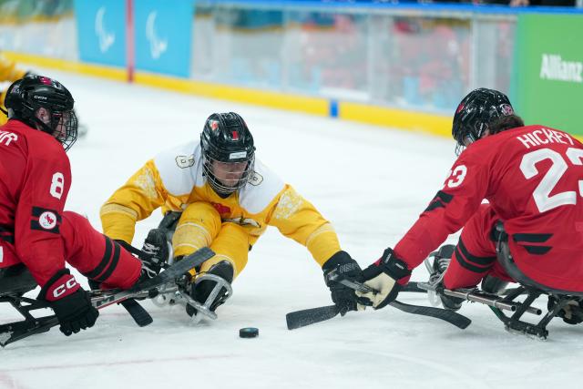 (260314) -- MILAN, March 14, 2026 (Xinhua) -- Wang Zhidong (C)of China vies with Tyler McGregor (L) and
Liam Hickey of Canada during the Para Ice Hockey semifinal match between the Canada and China at the Milan-Cortina 2026 Paralympic Winter Games in Milan , Italy, March 13, 2025. (Xinhua/Li Jing)