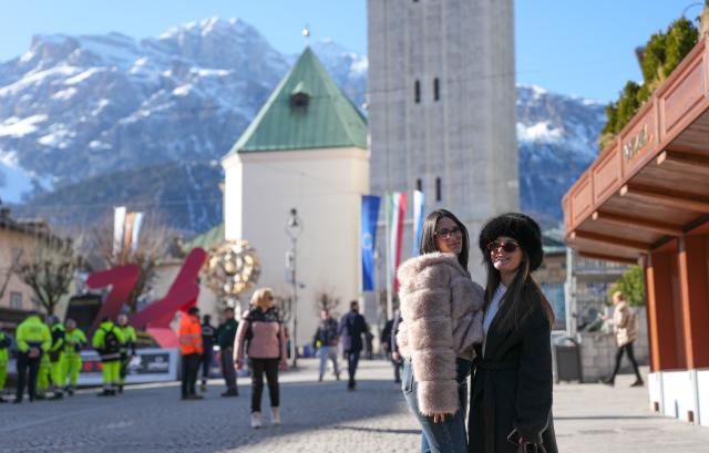 (260314) -- CORTINA D'AMPEZZO, March 14, 2026 (Xinhua) -- Tourists take photos at Piazza Angelo Dibona in Cortina d'Ampezzo, Italy, on March 4, 2026. Cortina d'Ampezzo, nestled in the Dolomites, a UNESCO World Heritage Site, is a winter sports destination that has hosted the Winter Olympics twice. The 1956 Winter Olympic Games left enduring venues such as the Cortina Curling Stadium, which hosted the curling events at the 2026 Winter Olympic Games and is hosting the wheelchair curling at the Paralympic Winter Games.  
Cortina's winter sports heritage dates back to 1897, with legendary slopes including the Olympia delle Tofane.
As the 2026 Paralympic Winter Games conclude on March 15, Cortina will host the closing ceremony. The flame's extinguishment here will symbolize unity, bridging 70 years of Olympic legacy. (Xinhua/Wang Kaiyan)