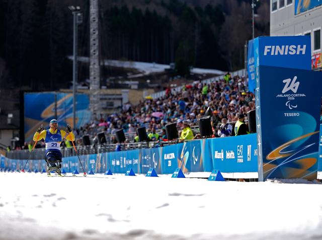 (260314) -- TESERO, March 14, 2026 (Xinhua) -- Yerbol Khamitov of Kazakhstan celebrates as he crosses the finish line during the para biathlon men's sprint pursuit sitting at the Milan-Cortina 2026 Paralympic Winter Games in Tesero, Italy, March 13, 2026. (Xinhua/Hou Zhaokang)