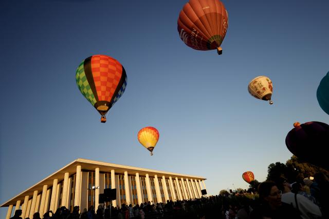 (260314) -- CANBERRA, March 14, 2026 (Xinhua) -- Hot air balloons fly over the National Library of Australia during the Canberra Balloon Spectacular in Canberra, Australia, March 14, 2026.
  The annual hot air balloon festival kicked off here on Saturday and lasts until March 22. (Photo by Chu Chen/Xinhua)