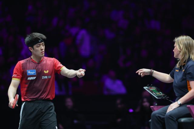 (260314) -- CHONGQING, March 14, 2026 (Xinhua) -- Qiu Dang (L) of Germany talks to the referee during the men's singles quarterfinal match between Wen Ruibo of China and Qiu Dang of Germany at the WTT Champions Chongqing 2026 in southwest China's Chongqing, March 14, 2026. (Xinhua/Huang Wei)