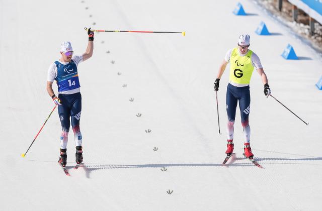 (260314) -- TESERO, March 14, 2026 (Xinhua) -- Jake Adicoff (L) and guide Reid Goble of the United States cross the finish line the para cross-country skiing mixed 4x2.5km relay at the Milan-Cortina 2026 Paralympic Winter Games in Tesero, Italy, March 14, 2026. (Xinhua/Hou Zhaokang)