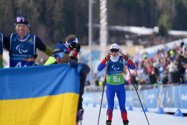 (260314) -- TESERO, March 14, 2026 (Xinhua) -- Anastasiia Bagiian (R) of Russia reacts after the para cross-country skiing mixed 4x2.5km relay at the Milan-Cortina 2026 Paralympic Winter Games in Tesero, Italy, March 14, 2026. (Xinhua/Lian Zhen)