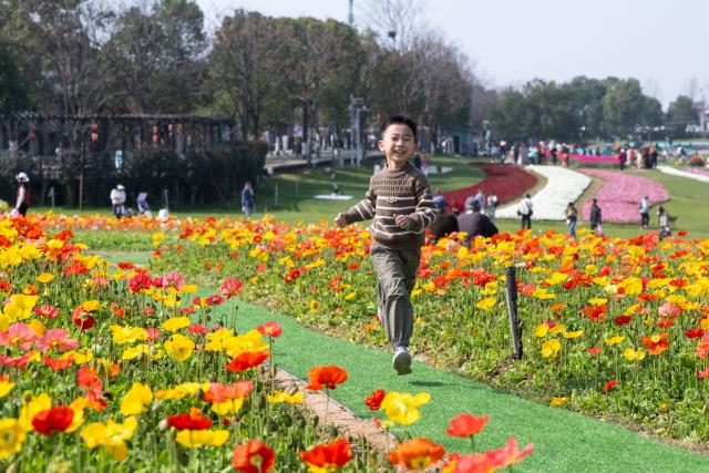 (260314) -- BEIJING, March 14, 2026 (Xinhua) -- A child plays at a park in Wuhan, central China's Hubei Province, March 14, 2026. (Xinhua/Xiao Yijiu)