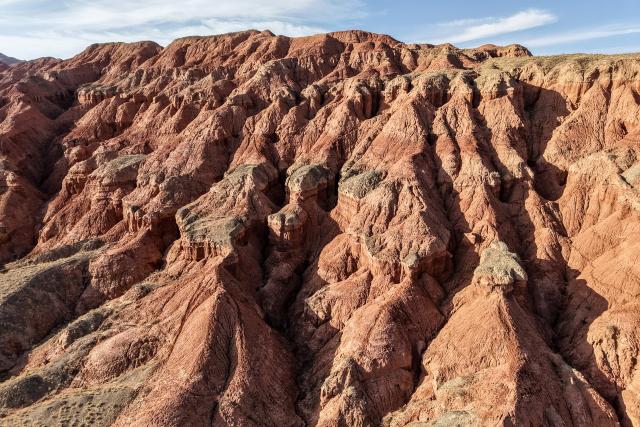 (260708) -- SUNAN, July 8, 2026 (Xinhua) -- An aerial drone photo taken on July 7, 2026 shows the view of a geopark in Sunan Yugur Autonomous County of Zhangye, northwest China's Gansu Province. The geopark covers an area of 17.34 square kilometers. The park features unique landforms with towering peaks, rugged mountains, jagged rock pillars, and vibrant colors. (Xinhua/Lang Bingbing)