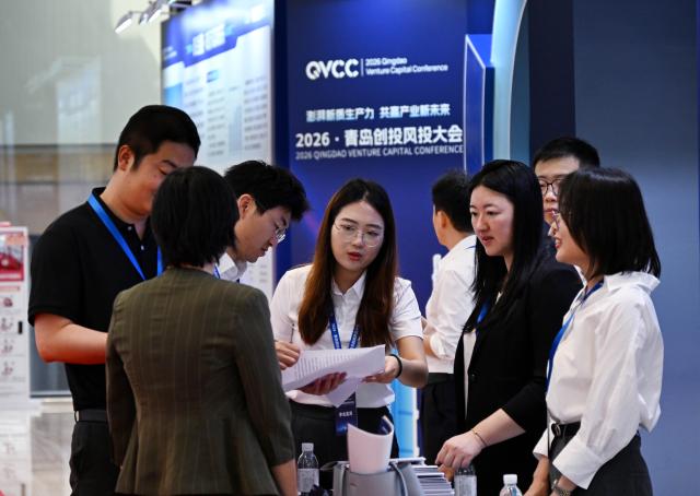 (260708) -- QINGDAO, July 8, 2026 (Xinhua) -- Attendees communicate during the 2026 Qingdao Venture Capital Conference at Qingdao International Conference Center in Qingdao, east China's Shandong Province, July 8, 2026. This conference focuses on the development of new quality productive forces and collaborative innovation in the fields of venture capital. (Xinhua/Li Ziheng)