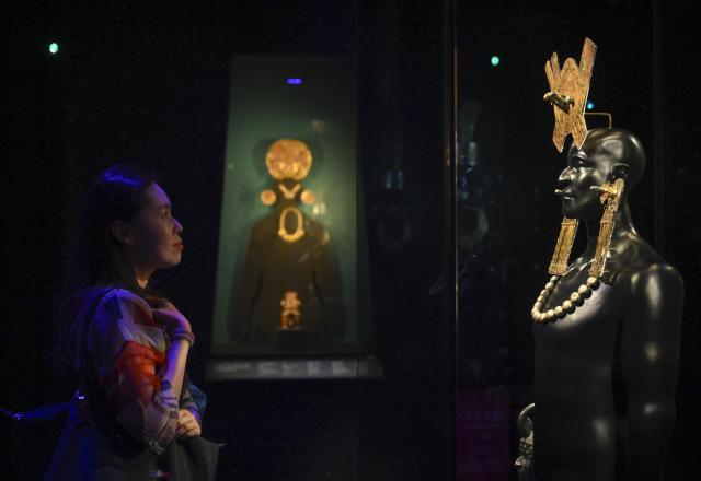 (260708) -- SHANGHAI, July 8, 2026 (Xinhua) -- A visitor views exhibits during the exhibition "On Top of the World Tree: Ancient Civilizations of the Americas" in Shanghai, east China, July 8, 2026. The exhibition showcases a total of 1,129 sets of precious artifacts from cultural institutions in Mexico, Peru and China. It will officially open to the public on July 9 and will run until Nov. 14, 2027. (Xinhua/Chen Haoming)