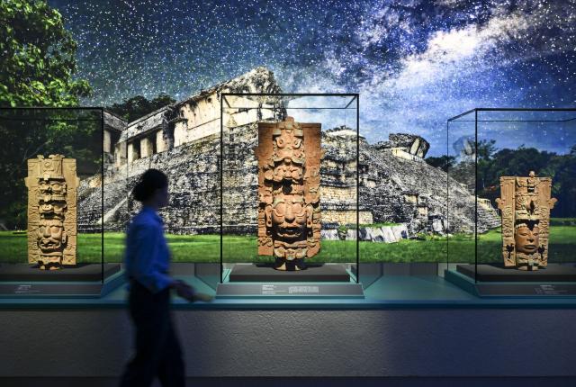 (260708) -- SHANGHAI, July 8, 2026 (Xinhua) -- A visitor views exhibits during the exhibition "On Top of the World Tree: Ancient Civilizations of the Americas" in Shanghai, east China, July 8, 2026. The exhibition showcases a total of 1,129 sets of precious artifacts from cultural institutions in Mexico, Peru and China. It will officially open to the public on July 9 and will run until Nov. 14, 2027. (Xinhua/Chen Haoming)