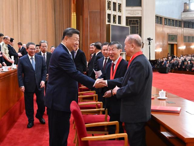 (260708) -- BEIJING, July 8, 2026 (Xinhua) -- Chinese President Xi Jinping, also general secretary of the Communist Party of China Central Committee and chairman of the Central Military Commission, talks with the two national top sci-tech award winners Chen Liquan, a researcher at the Institute of Physics under the Chinese Academy of Sciences (CAS) and a Chinese Academy of Engineering (CAE) academician, and Ben De, a researcher at the China Electronics Technology Group Corporation and also a CAE academician, after a meeting bringing together the national science and technology award conference, the general assemblies of the members of the CAS and the CAE, and the 11th national congress of the China Association for Science and Technology at the Great Hall of the People in Beijing, capital of China, July 8, 2026. (Xinhua/Xie Huanchi)