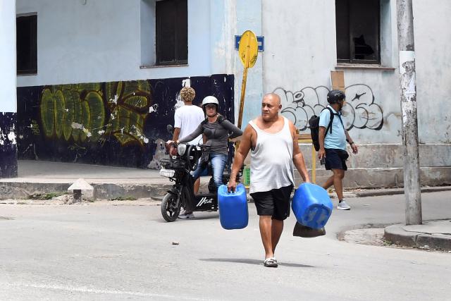 (260708) -- HAVANA, July 8, 2026 (Xinhua) -- A man carrying water vessels walks along a street in Havana, capital of Cuba, on July 8, 2026. Cuban Foreign Minister Bruno Rodriguez on Tuesday accused the U.S. government of carrying out "multidimensional, non-conventional warfare" against Cuba, which he said has lasted for almost seven decades and "become ever crueler and more ruthless during the last seven months."
The cumulative damage caused by the U.S. blockade since it was first imposed amounts to 178.7 billion U.S. dollars at current prices, according to Rodriguez. (Photo by Joaquin Hernandez/Xinhua)